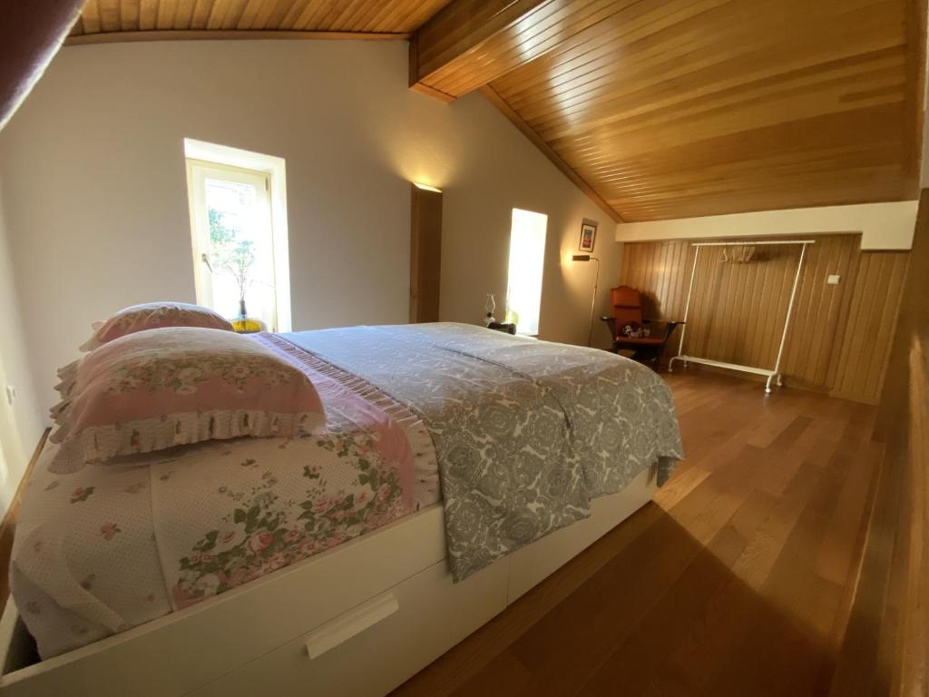 ein Schlafzimmer mit einem großen Bett mit Holzboden in der Unterkunft Casa dos Capitães Mores - Vila Flor in Vila Flor