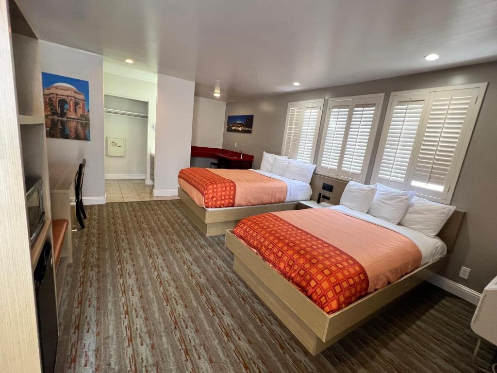 a hotel room with two beds and a television at Presidio Parkway Inn in San Francisco