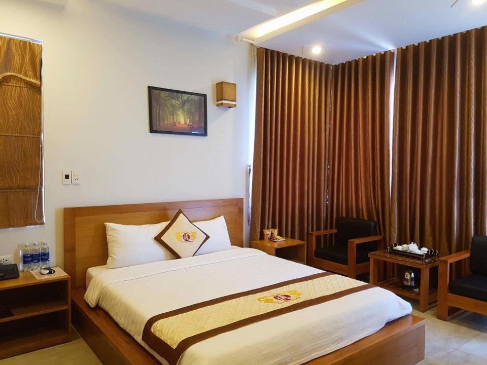 ダナンにあるTân Hoàng Long Hotel DN by - BAY LUXURYのベッドと椅子のあるホテルの部屋