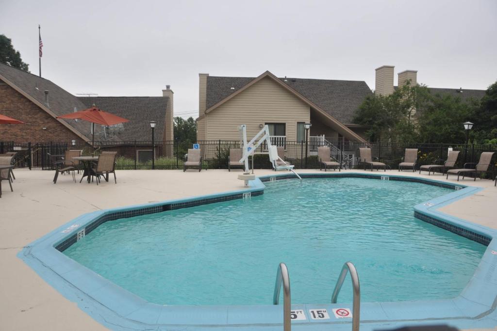 a large swimming pool in a yard with chairs at Residence Inn Shelton Fairfield County in Shelton