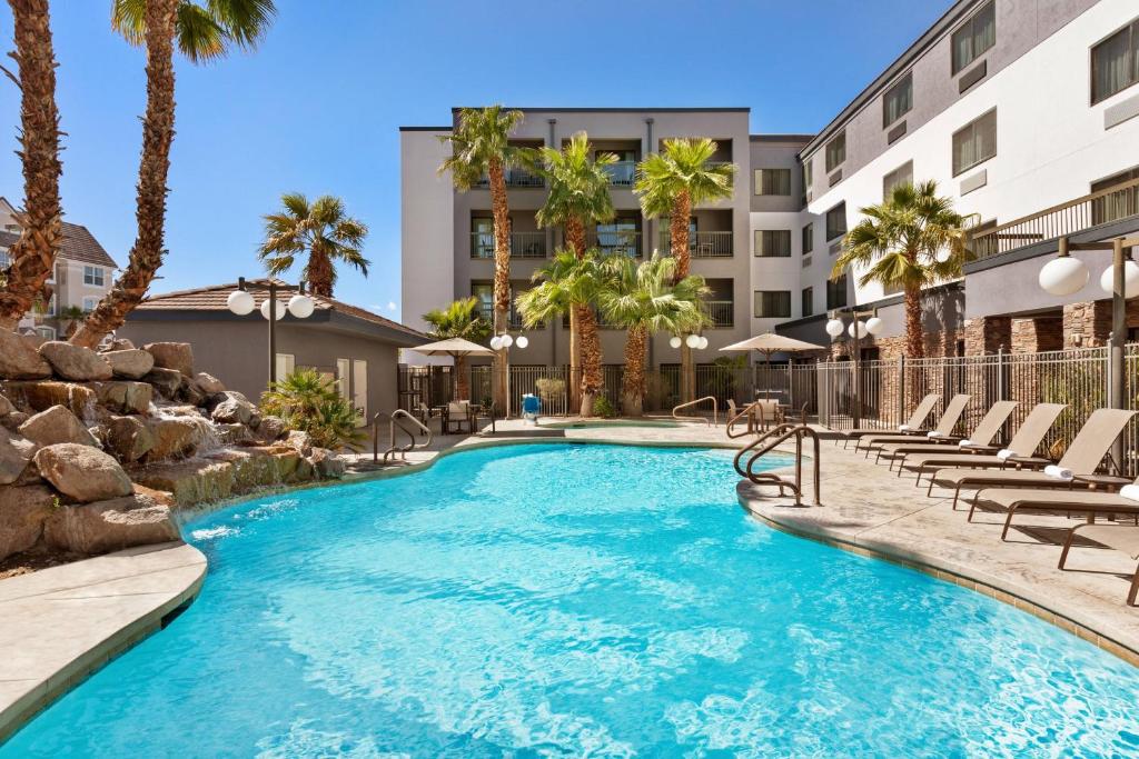 una piscina con sedie a sdraio e un edificio di Courtyard By Marriott Las Vegas Stadium Area a Las Vegas