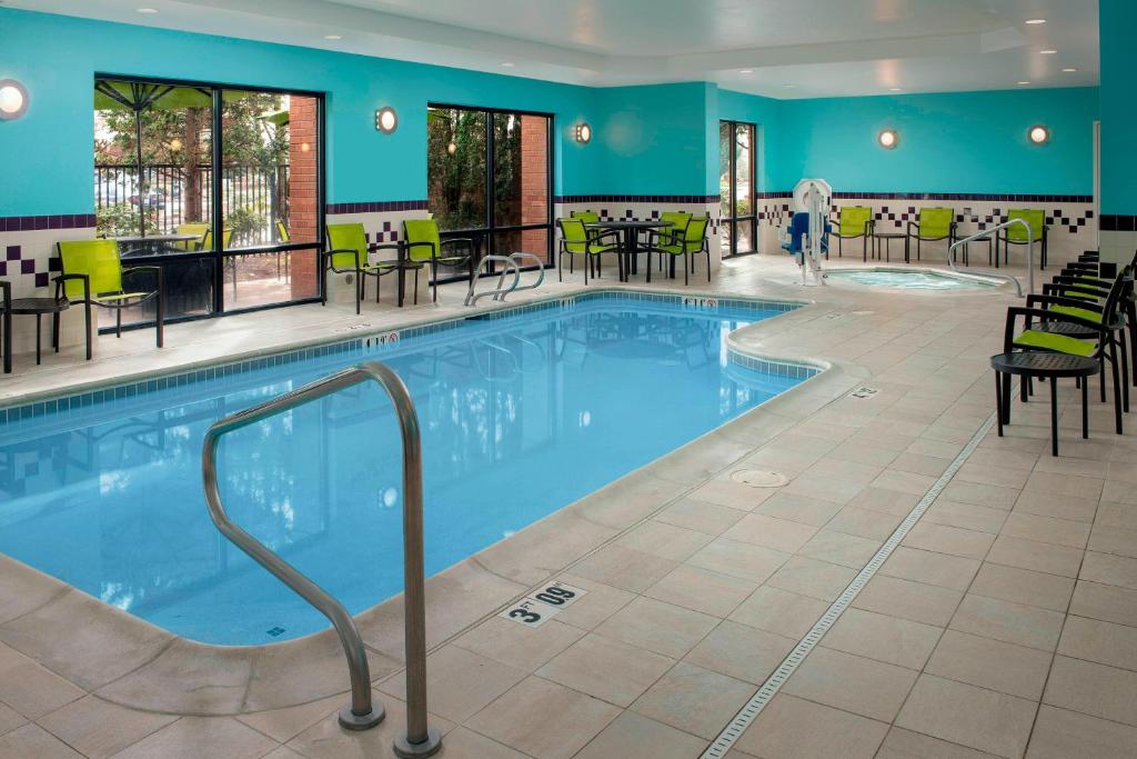 a pool in a hotel with tables and chairs at SpringHill Suites by Marriott Portland Hillsboro in Hillsboro