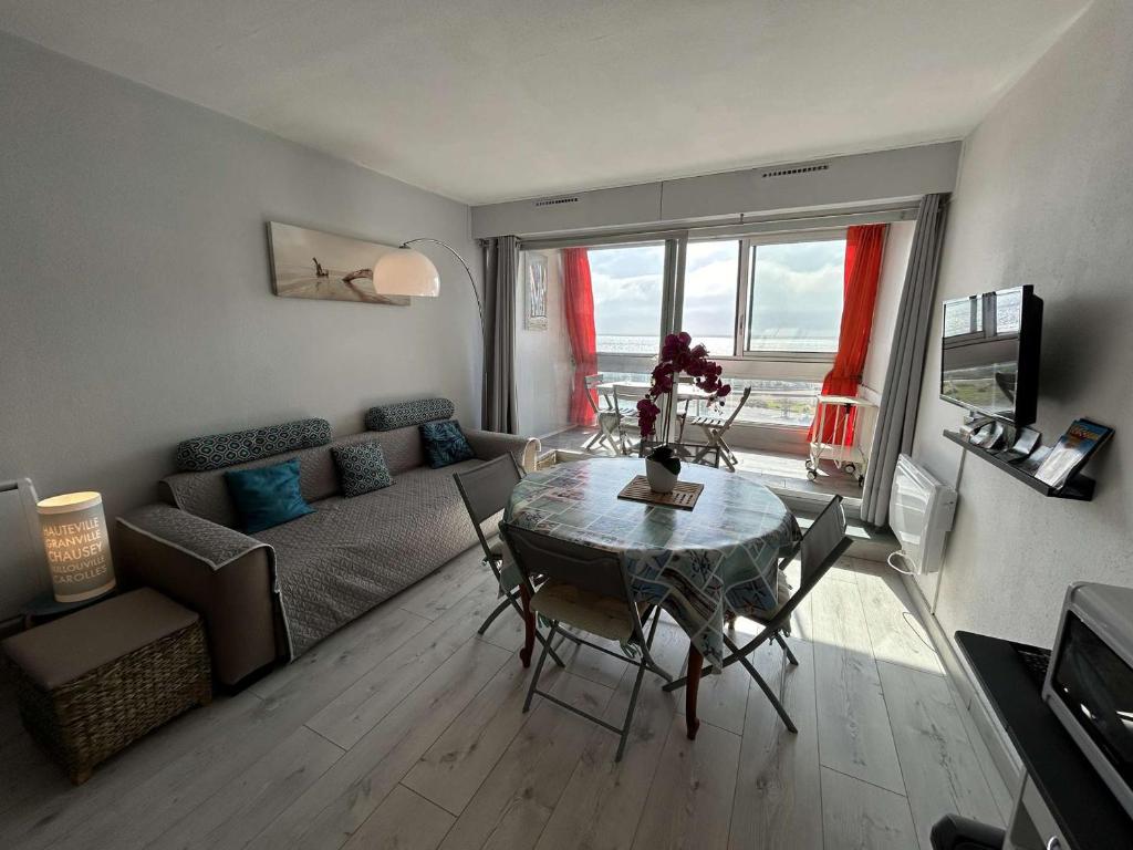 un salon avec une table et un canapé dans l'établissement Appartement Studio cabine, 4 couchages, face à la mer - FR-1-224C-304, à Saint-Jean-de-Monts