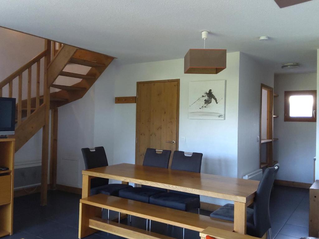 une salle à manger avec une table et des chaises en bois dans l'établissement Appartement avec balcon, piscine, sauna et parking - 8 personnes, Arc 1600 - FR-1-411-941, à Bourg-Saint-Maurice
