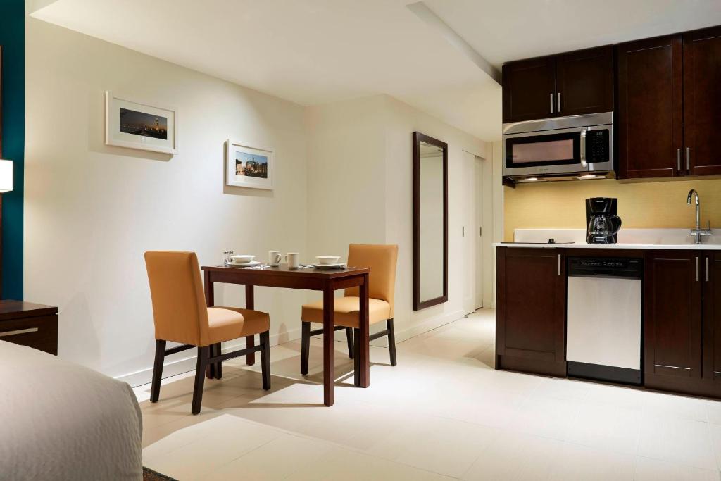 a kitchen and dining room with a table and chairs at Residence Inn by Marriott Montréal Downtown in Montréal