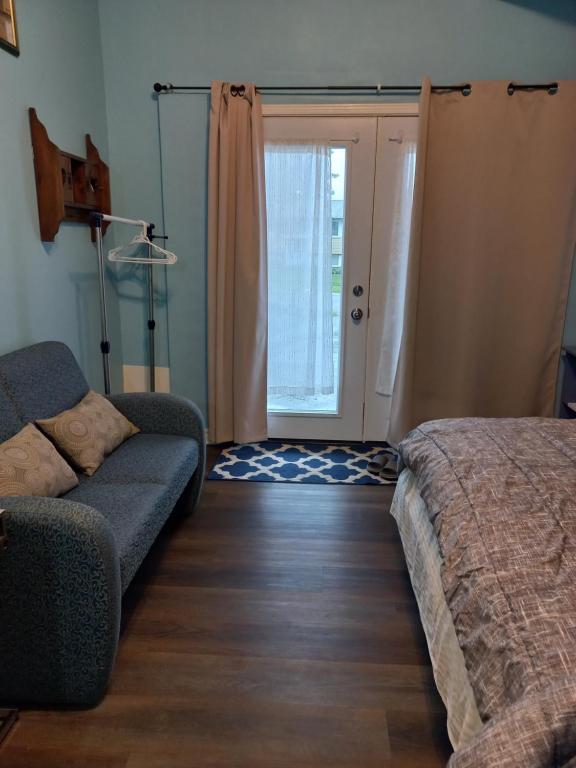 salon z kanapą, łóżkiem i drzwiami w obiekcie Amor Bayridge w mieście Kingston