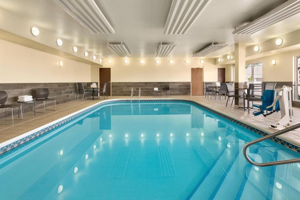 a pool in a hotel with chairs and tables at Fairfield Inn Erie Millcreek Mall in Erie