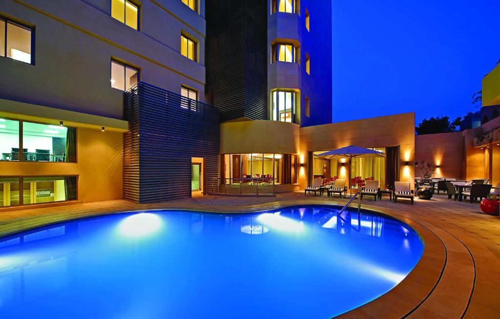 a swimming pool in front of a building at night at Corp Amman Hotel in Amman