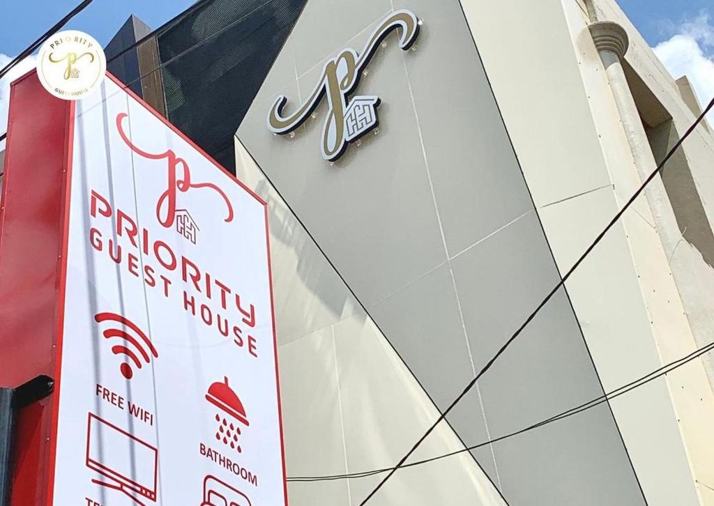un negozio con un cartello sul lato di un edificio di Priority Guest House Samarinda a Samarinda