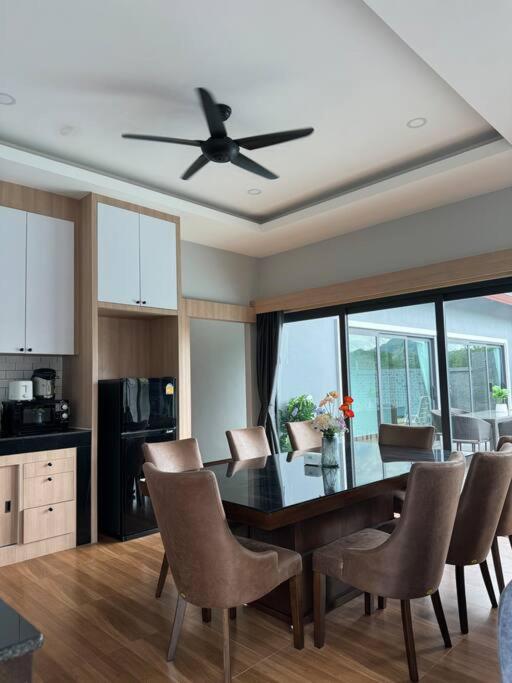 a kitchen with a table and chairs and a ceiling fan at Sun Ray Private Pool villa 3 bed in Ao Nang 