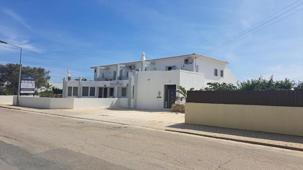 uma casa branca ao lado de uma rua em Amigos para Sempre - Casa de Hóspedes em Ferragudo