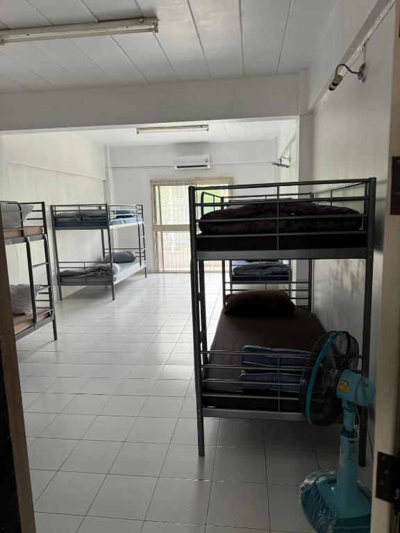 a room with bunk beds in a room with a tile floor at JS786 Cafe&Bistro in Pattaya