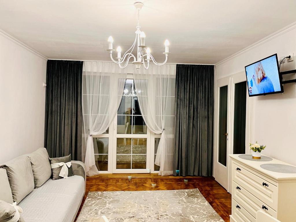 Una sala de estar con un sofá y una ventana. en Dream Rooms, en Hunedoara