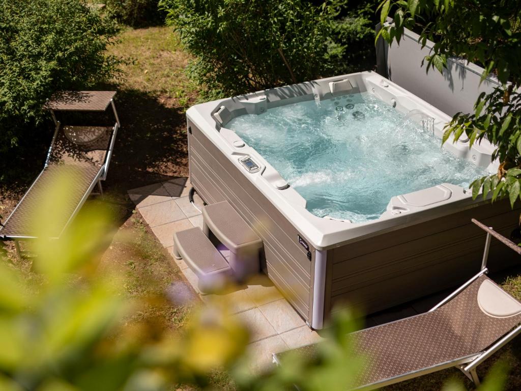 a hot tub sitting on a patio in a yard at Villa Atelier Baron Killi in Caldaro
