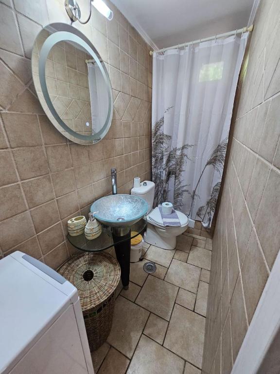 łazienka z umywalką, toaletą i lustrem w obiekcie Beachfront House 13 ,Glyfada w mieście Glifada