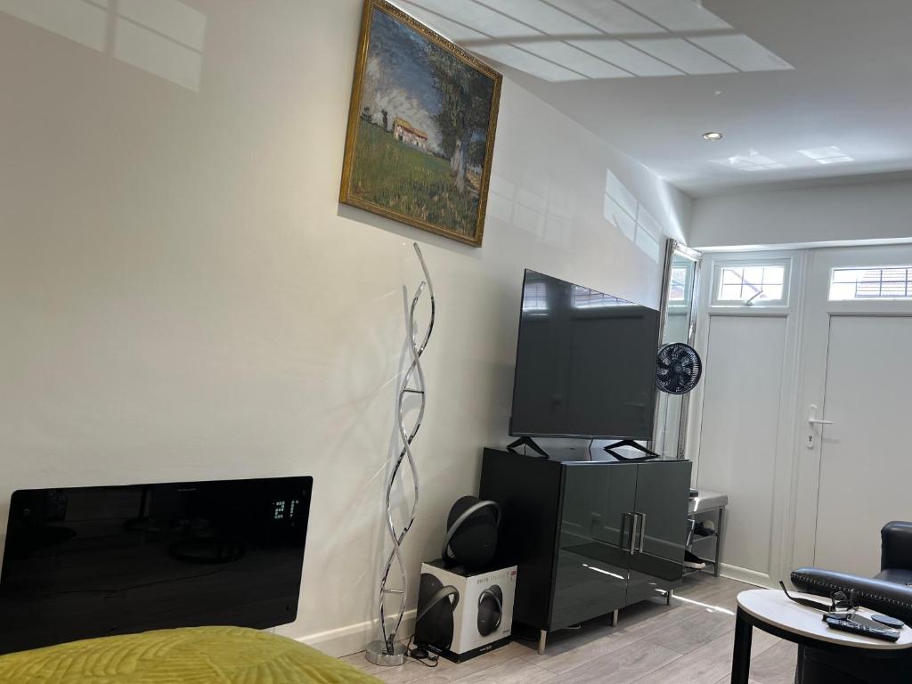 a bedroom with a bed and a tv and a table at Franky's Place luxury apartment in The Hyde