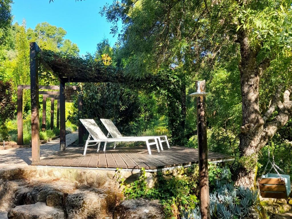 a white bench sitting on a wooden deck at Fragas do Lobo - Casa da Azenha in Castelo Novo