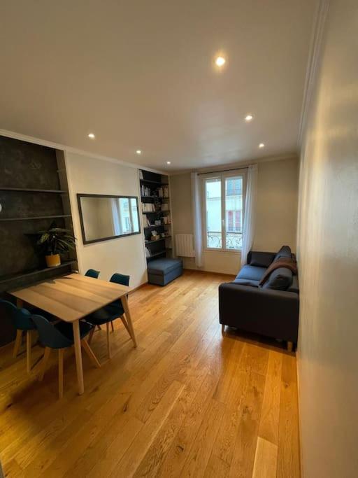 un salon avec une table et un canapé dans l'établissement Cocon chaleureux & charmant - Nation, à Paris