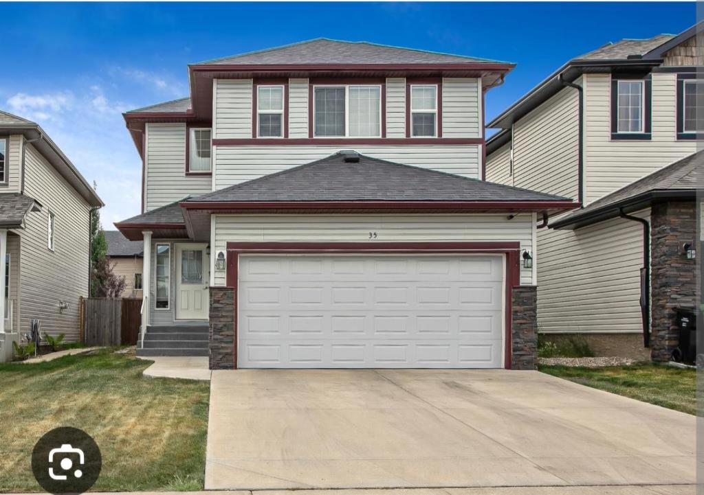 a house with a garage door in front of it at Rome, Sweet Home in Calgary