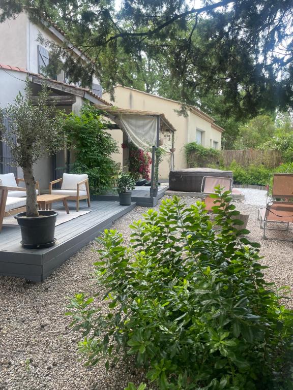 un patio avec une table, des chaises et un grill dans l'établissement Charmante maison de location à Blauzac (30), à Blauzac