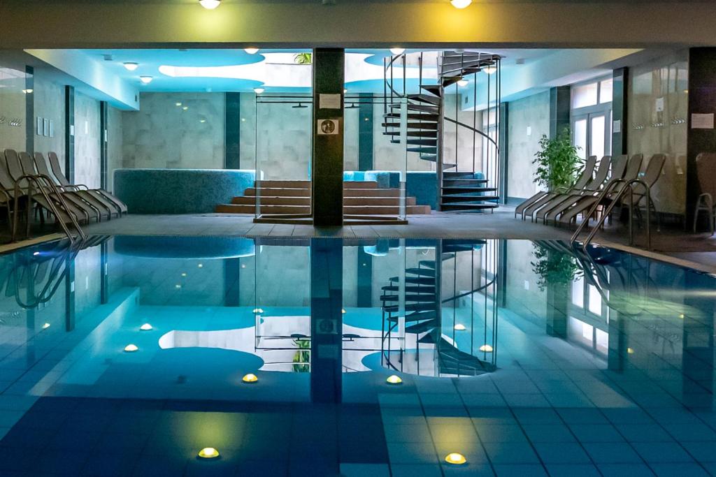 basen z krzesłami i schodami w budynku w obiekcie Hotel Vital w Zalakaros