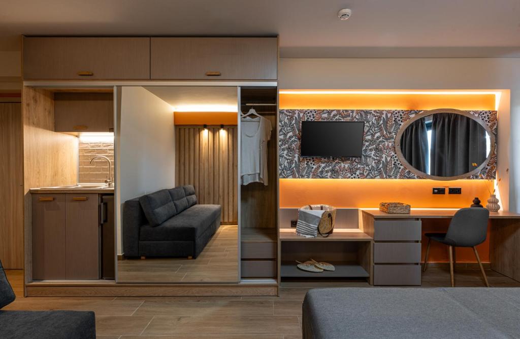 a room with a desk and a chair and a television at Nerium Apartments Leptokaria in Leptokarya