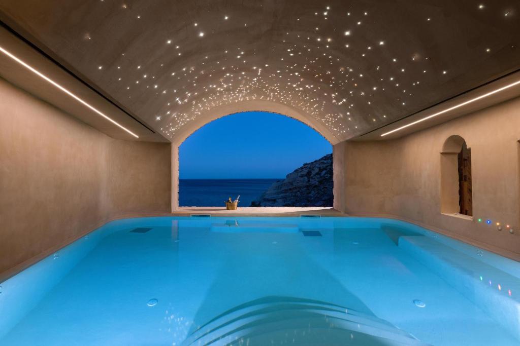 a swimming pool with a view of the ocean at Stone Luxury Suites - Adults Only in Archangelos