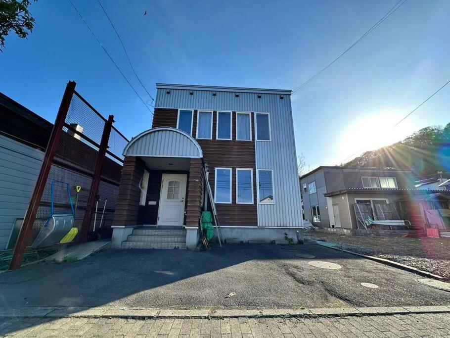 a house with the sun shining on it at Shakotan Detached House Stay in Shakotan