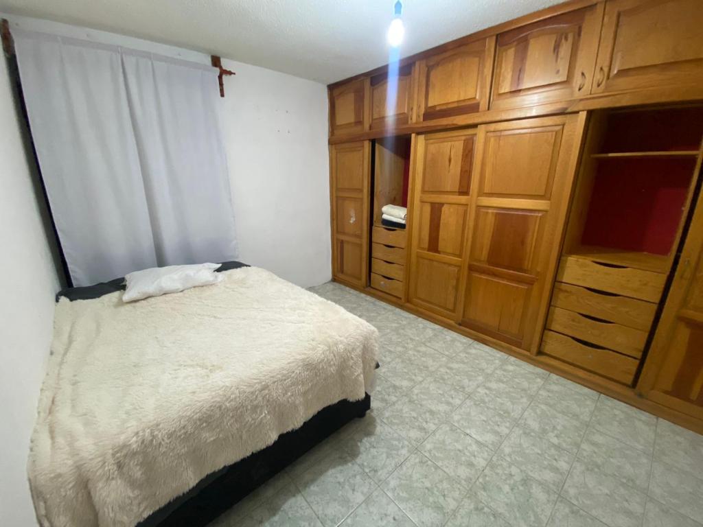 sypialnia z łóżkiem i drewnianymi szafkami w obiekcie Casa Oaxaca w mieście Santa María Azompa