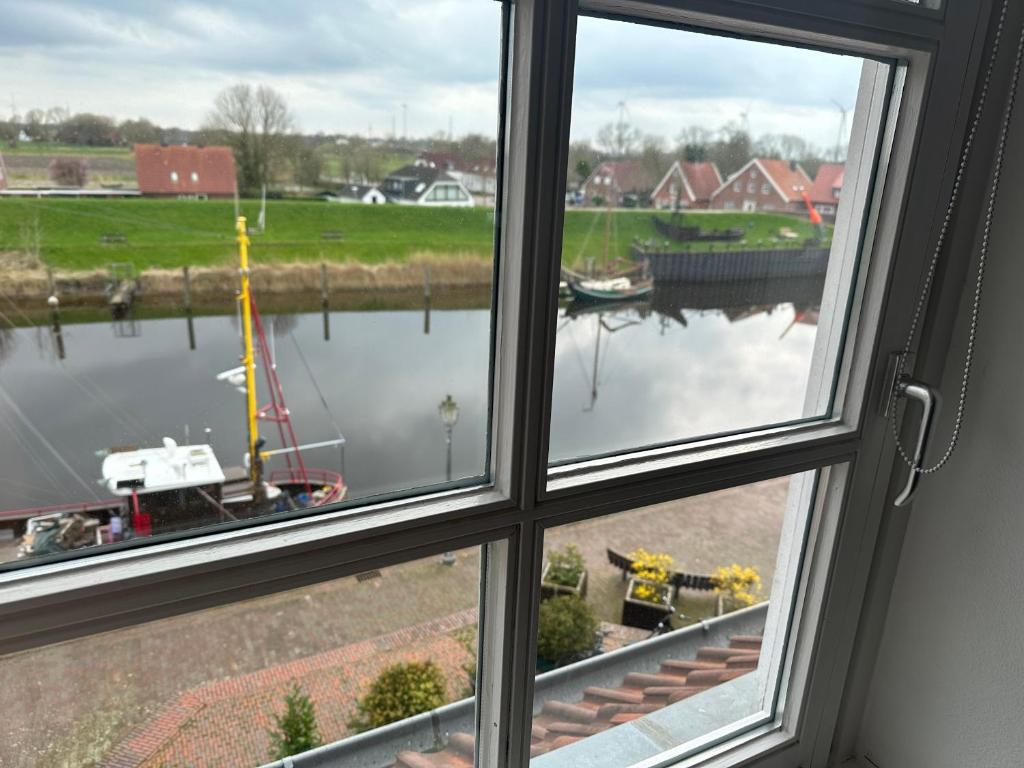 ein Fenster mit Blick auf einen Wasserkörper in der Unterkunft Ferienwohnung am Alten Hafen in Hooksiel