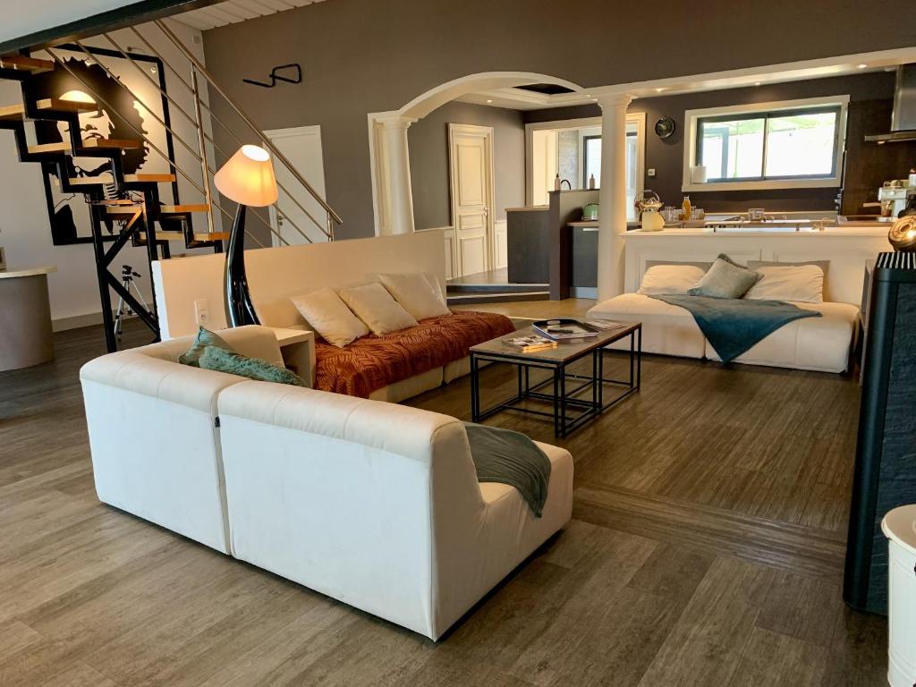 un salon avec un canapé et une table dans l'établissement Magnifique Loft 160m2 x 6 pers Proche plage, à Les Sables-dʼOlonne