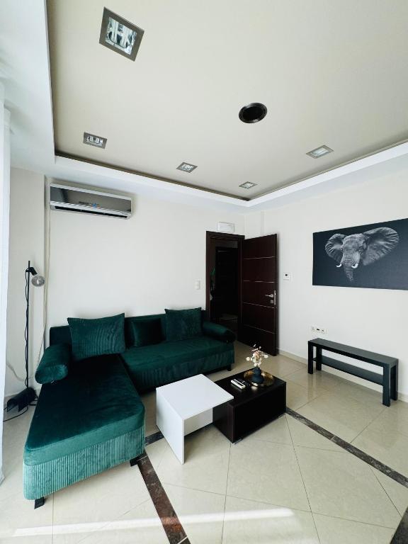 a living room with a green couch and a table at Elite Haven in Alexandroupoli