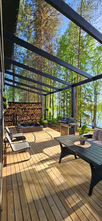 eine Terrasse mit einer Bank, einem Tisch und einem Grill in der Unterkunft Ternu Minivilla in Rovaniemi