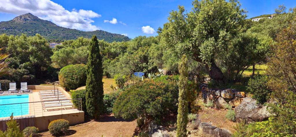 een villa met een zwembad en een berg bij Hotel Cala di l'Oru in LʼÎle-Rousse