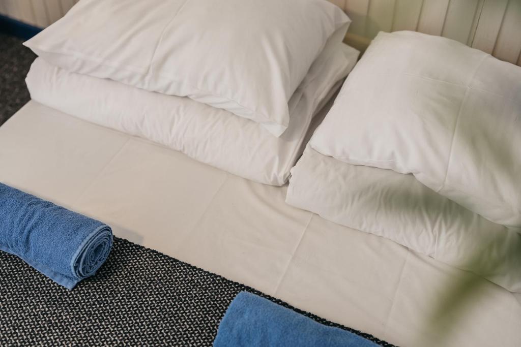 a bed with white sheets and pillows on it at Guboja in Nida