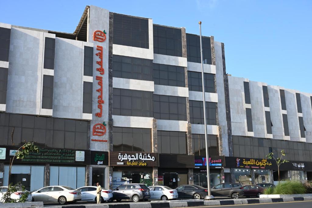 a large building with cars parked in front of it at بالمر للشقق المخدومة in Jazan