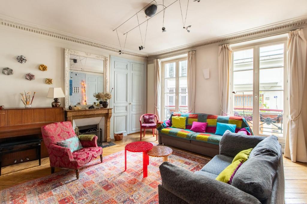 - un salon avec un canapé et un piano dans l'établissement Géranimus Enghien, à Paris