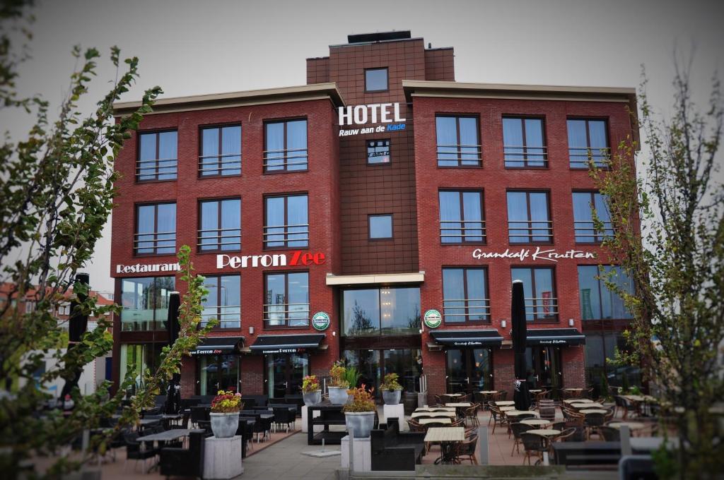 a hotel with tables and chairs in front of it at Hotel Rauw aan de Kade in IJmuiden