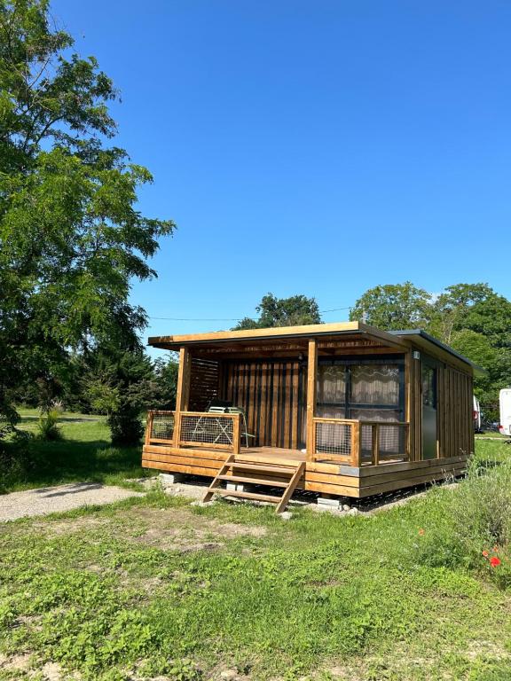 a wooden cabin in a field with trees at CAMPING ONLYCAMP VAUBAN in Neuf-Brisach