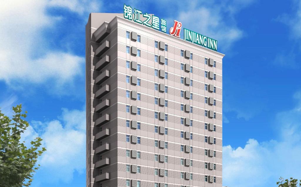 Un palazzo alto con un cartello sopra. di Jinjiang Inn Luoyang Wangcheng Park a Luoyang