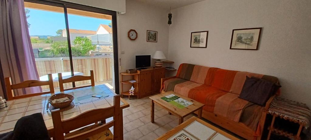 un salon avec un canapé et une table dans l'établissement Appartement 2 pièces à Saint Aygulf-Fréjus, à Fréjus