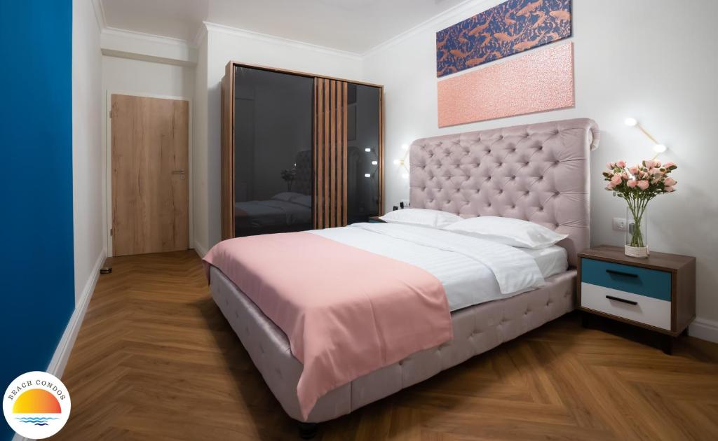 a bedroom with a large bed with a large headboard at Mamaia Beach Condos 2 in Năvodari