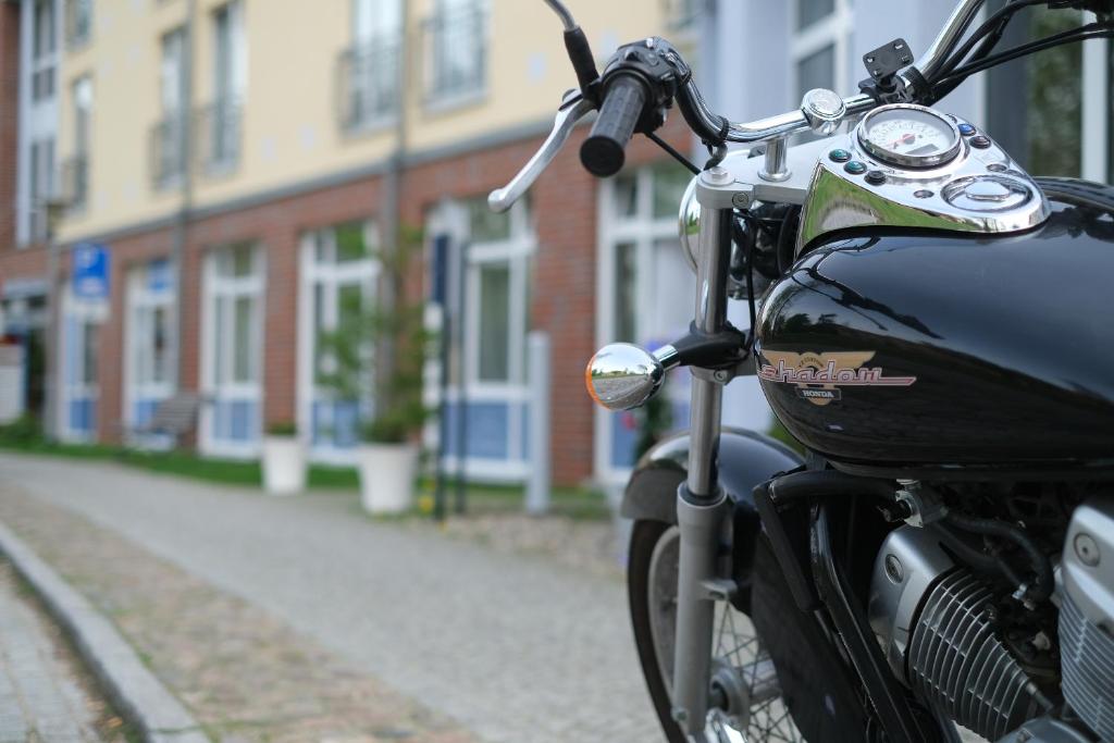 a black motorcycle parked on the side of a street at Hotel & Restaurant am Schlosspark in Dahme