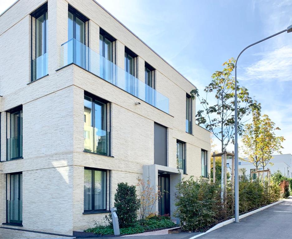 a white brick building with a blue balcony at Charmantes Studio nah der Innenstadt und Google HQ in Zürich