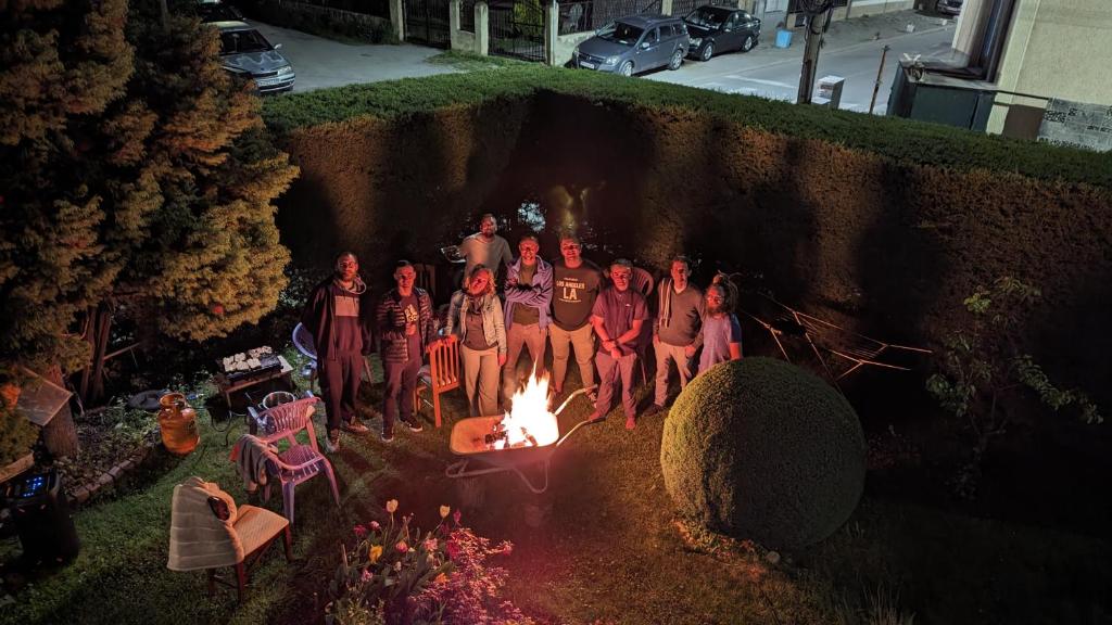 a group of people sitting around a fire at Golden Age Hostel in Ohrid