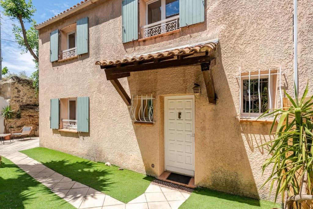 a building with a white door and a yard at Maison de vacances Marseille in Marseille