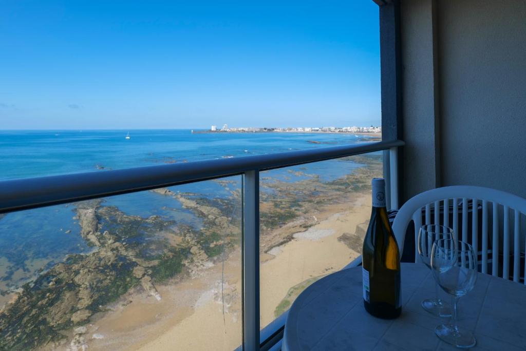 - une bouteille de vin assise sur une table avec vue sur l'océan dans l'établissement Joli appartement renove vue mer, Les Sables 4 personnes, à Les Sables-dʼOlonne