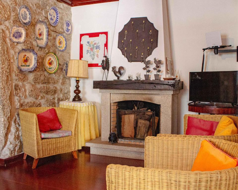 - un salon avec deux chaises et une cheminée dans l'établissement Casa das Fontes, à Ponte da Barca
