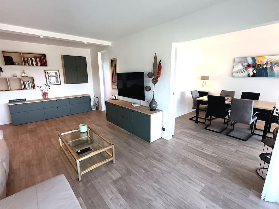 un salon avec une télévision et une salle à manger dans l'établissement Appartement spacieux avec terrasse en plein centre, à Anglet