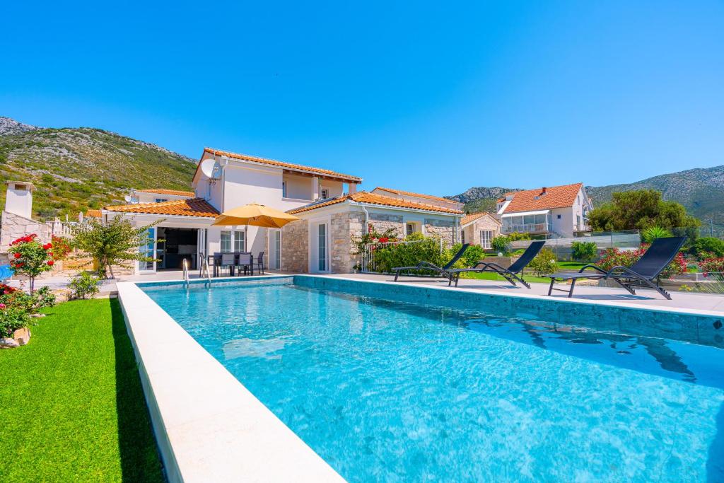 a villa with a swimming pool and a house at Villa Mirage with Private Heated Pool in Orebić